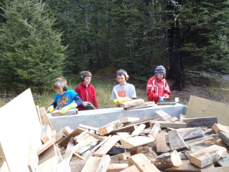 Junior members loading firewood onto trailer 